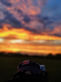 Close-up of man on field against sky during sunset