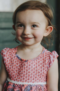 Cute smiling girl looking away while standing at home