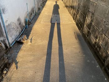 High angle view of people shadow on footpath