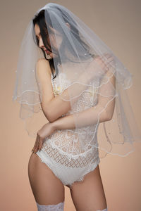 Midsection of woman standing against gray background