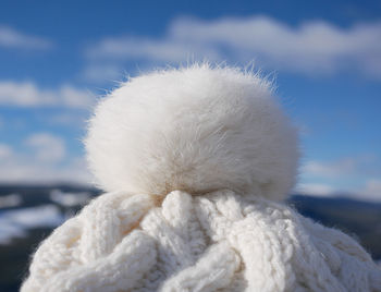 Close-up of white wool hat against sky