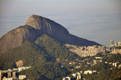 Scenic view of houses by mountain at morro dois irmaos against sea