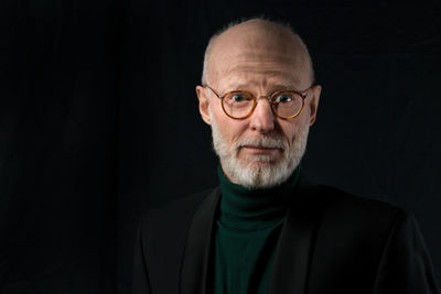 Portrait of man against black background