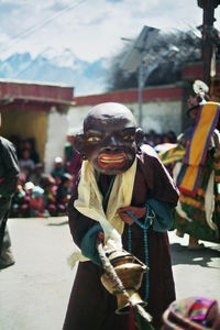 Performer in costume dancing outside temple during festival
