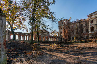 Old building by trees against sky