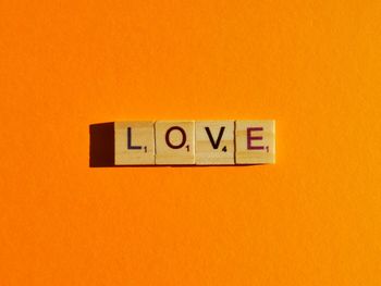 Low angle view of sign against orange wall