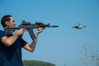 Side view of man holding drone