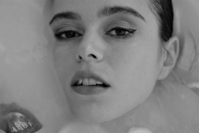 Close-up portrait of woman taking bath with fruits in bathtub