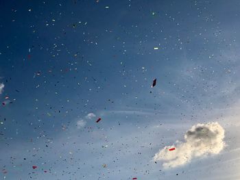 Low angle view of kites flying in sky