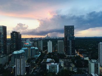 Aerial view of buildings in city against sky during sunset