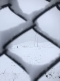 Close-up of snow on metal fence during winter