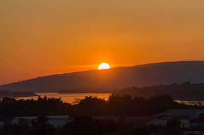 Scenic view of silhouette mountains against orange sky