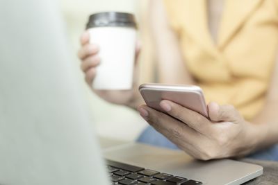 Midsection of man using mobile phone
