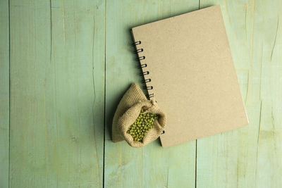 Directly above shot of mung beans by spiral notebook on table