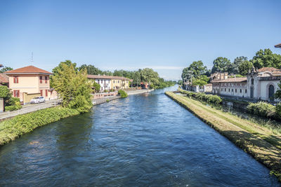 River amidst buildings against clear blue sky