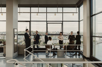 Happy businessmen with female colleagues mingling during office party