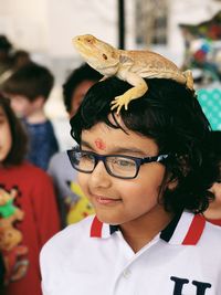 Cute girl with iguana on head at home