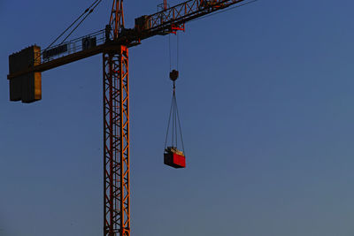 Low angle view of crane against clear sky