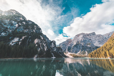 Scenic view of lake and mountains against cloudy sky