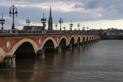 Pont de pierre over garonne river against cloudy sky