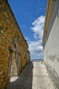 Stone wall by sea against sky