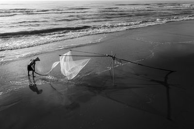 Fisherman working with net at beach