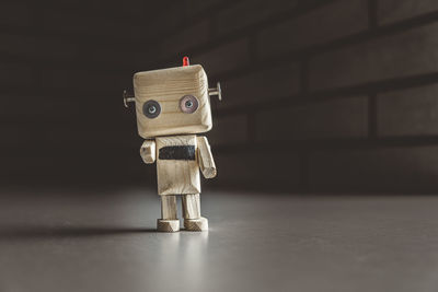 Lonely wooden android robot in a dark place is pointing at you. loneliness concept