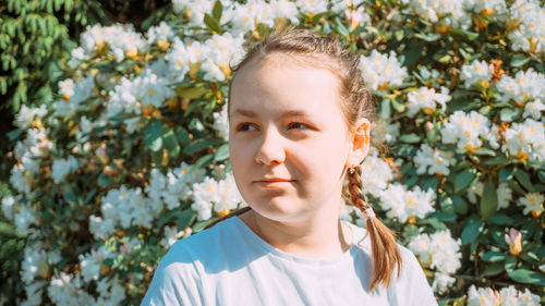 Portrait of young woman against plants