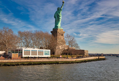The statue of liberty in  nyc usa daylight view in liberty island with clouds in the sky 