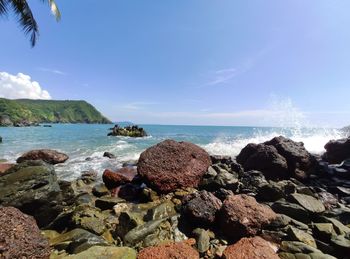 Rocks on beach against sky