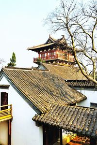 Exterior of house by building against clear sky