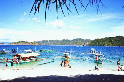Panoramic view of people on beach against sky