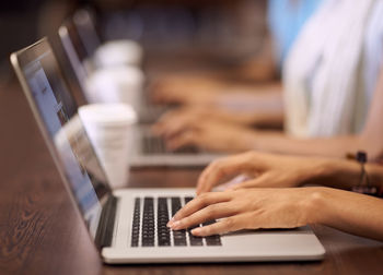Midsection of man using laptop at table