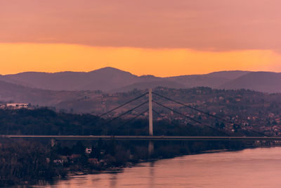 Bridge over river against sky during sunset