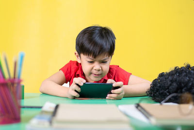 Portrait of boy sitting on table