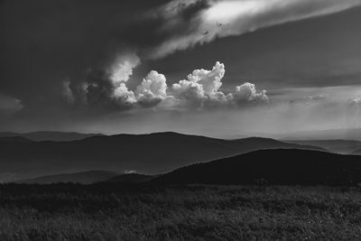 Scenic view of land and mountains against sky