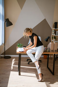 Pensive woman in office planning work schedule in notebook. sitting