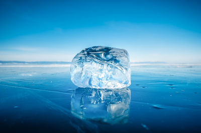 Close-up of ice crystals against blue sea