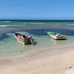 Boats moored on sea against sky