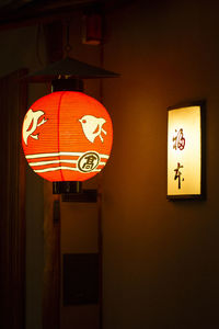 Close-up of illuminated lantern hanging against wall