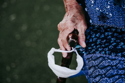 Midsection of woman holding camera against blurred background