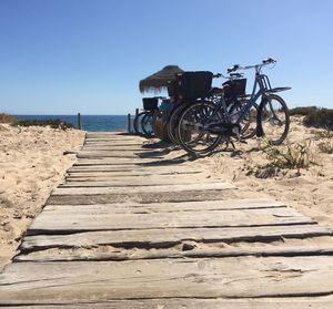 Bicycle on beach against clear sky