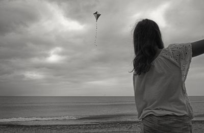 Rear view of woman looking at sea against sky