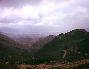 Scenic view of mountains against cloudy sky