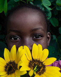 Close-up of a child with a yellow flower