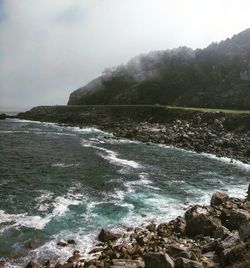 Scenic view of sea and mountains against sky