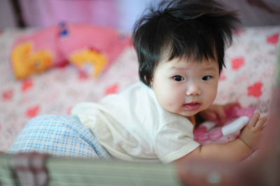 Portrait of cute baby girl in crib