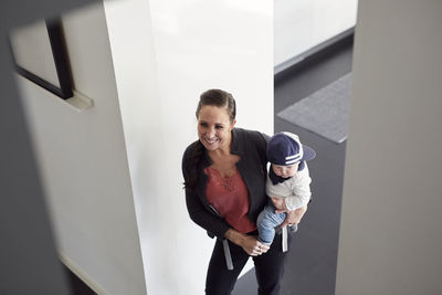 Smiling woman carrying baby son