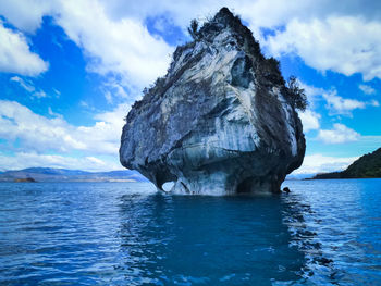 Rock formation in sea against sky