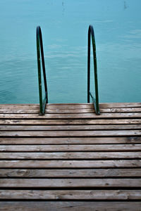 Railing on wooden pier by lake